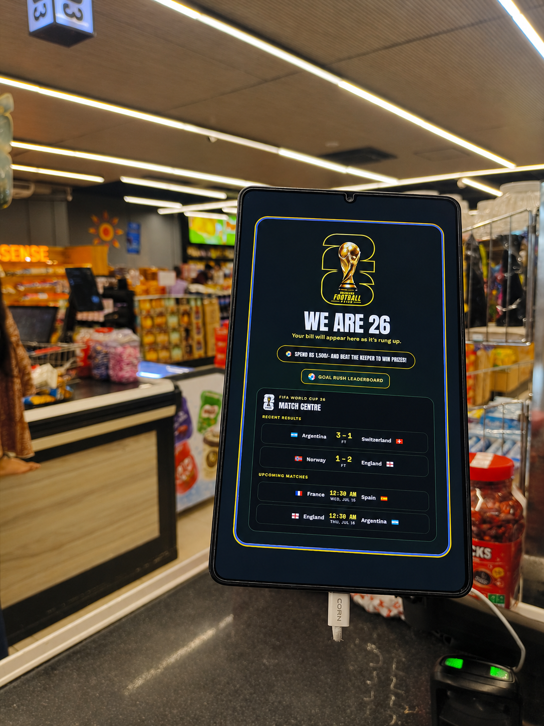 A football-themed digital display at a Mahajana Super checkout area.
